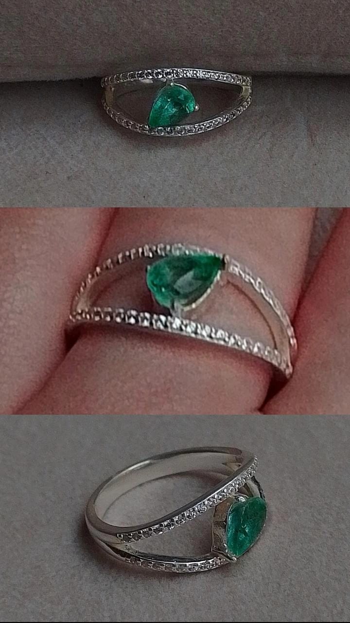 Este anillo de plata 925 es una pieza de joyería elegante y sofisticada, con un diseño moderno y delicado. La montura en plata de ley realza la belleza de una esmeralda natural en forma de lágrima, cuyo tono verde vibrante transmite lujo y distinción. El diseño de la banda se caracteriza por una curva sutil y envolvente, engastada con pequeñas piedras brillantes que añaden un toque de luminosidad y contraste con la esmeralda central. La disposición asimétrica y fluida del anillo resalta la piedra preciosa de manera única, permitiendo que la esmeralda sea la protagonista de la joya. Este anillo es una opción ideal para quienes buscan una joya con un equilibrio perfecto entre elegancia y modernidad, ideal para ocasiones especiales o para llevar como un símbolo de buen gusto y exclusividad.